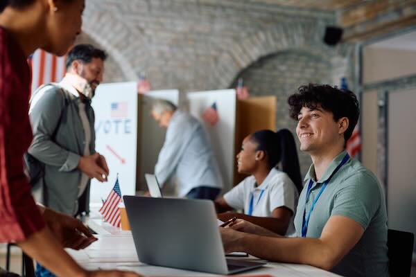 Happy man working as polling station volunteer during US elections.