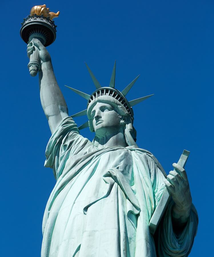 The Statue of Liberty with a clear blue sky behind it.